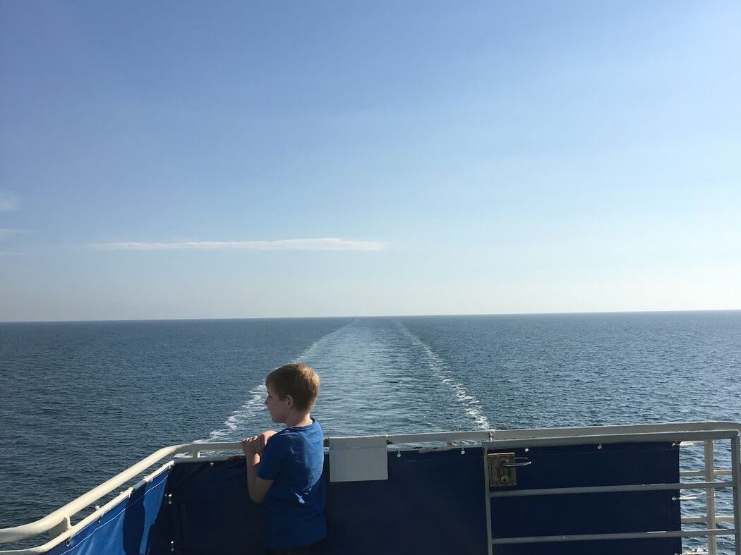 Kind an der Reling einer Fähre auf offener See